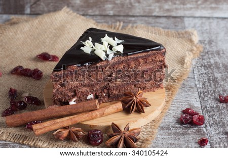 Dark chocolate cake on wooden rustic background. Cinnamon and spices. Dried orange. Sweets and diet.