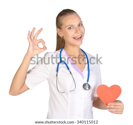 Woman intern holding paper heart in her hand and showing sign of okay.