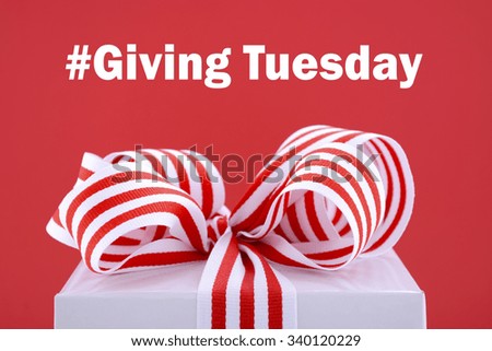 Red and white gift symbolic for Giving Tuesday with sample text on bright red and white background.  Royalty-Free Stock Photo #340120229