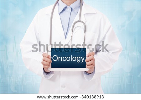 Doctor holding a tablet pc with Oncology sign on blue background Royalty-Free Stock Photo #340138913