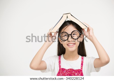 Portrait of happy little Asian child holding a book on isolated background