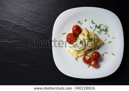 Chicken breast baked with mozzarella cheese and tomatoes on white plate. Top view