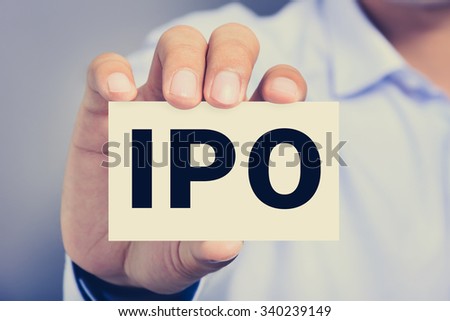 IPO letters  (or Initial Public Offering) on the card held by a man hand, vintage tone