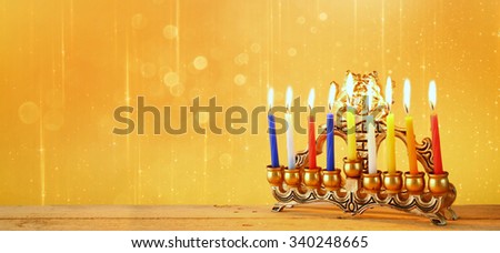 website banner image of of jewish holiday Hanukkah with menorah (traditional Candelabra). retro filtered. glitter overlay