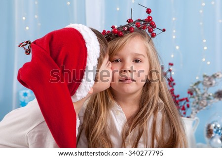 Little brother, giving a kiss to his sister, studio shot, Christmas concept