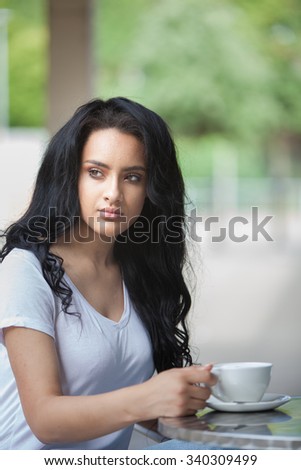pretty young teen drinking coffee outside a cafe