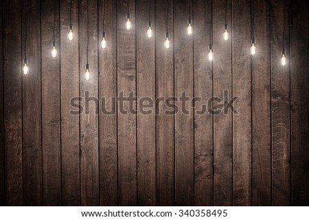 Light bulbs on dark Wooden Background  Royalty-Free Stock Photo #340358495
