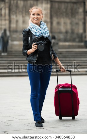 Europenian young girl taking pictures of sights at city excursion
