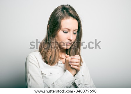 Business girl praying. studio photo on a gray background
