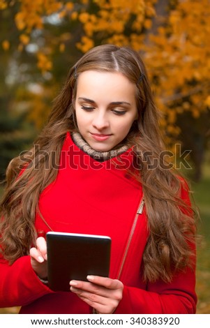 The young beautiful woman walks in autumn park.