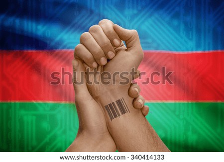 Barcode ID number tattoo on wrist of dark skinned person and national flag on background - Azerbaijan