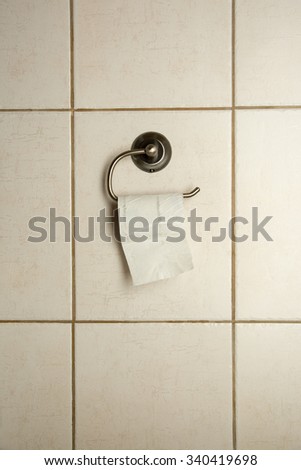 Empty toilet paper roll on white wall, empty space for text.Close-up. Royalty-Free Stock Photo #340419698