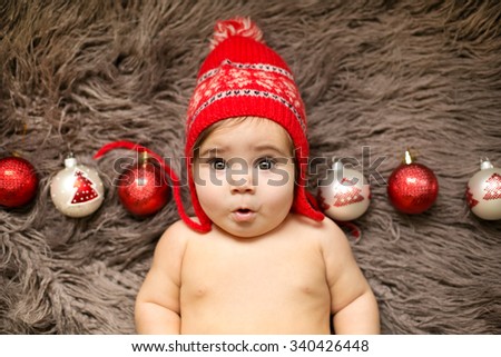 Cute girl in the red christmas hat with the christmas toys