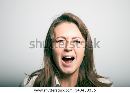 student girl shouts. office manager. studio photo on a gray background