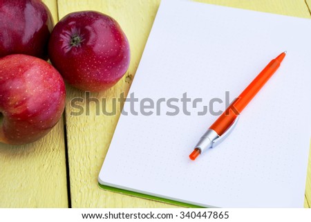 red apples Pen, Paper  on a Wood Background. recipe or diet concept, selective focus