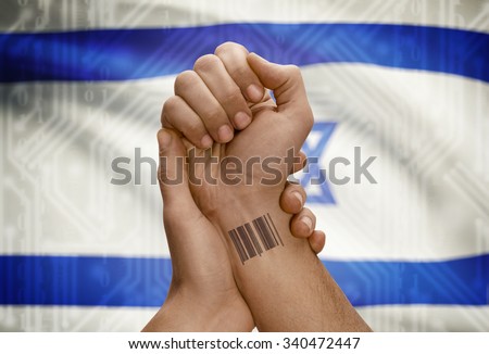 Barcode ID number tattoo on wrist of dark skinned person and national flag on background - Israel