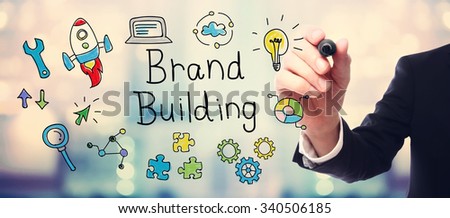 Businessman drawing Brand Building concept on blurred abstract background 