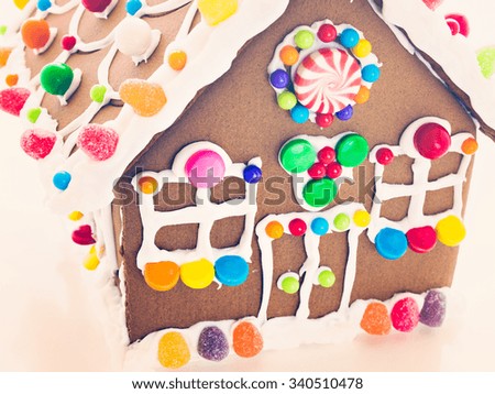 Decorated gingerbread house on white background.
