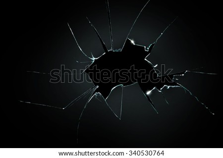 broken cracked glass with big hole over black background Royalty-Free Stock Photo #340530764