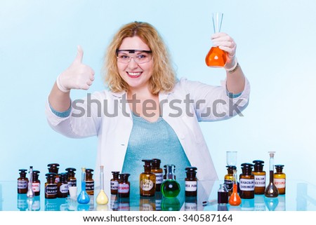 Experiments in laboratory. Happy chemist woman or student girl scientific researcher with chemical glassware test flask making ok hand sign on blue