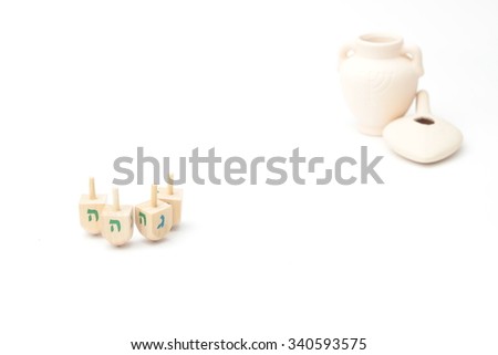 Jewish holiday hanukkah celebration - Dreidels, jug, oil, currencies, and gift boxes on a white background isolated