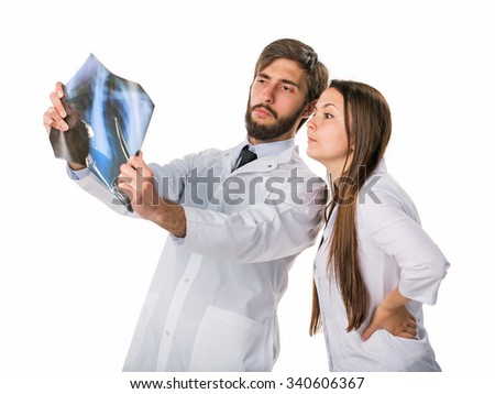 Two young attractive doctors looking at x-ray and taking .