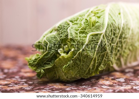 Closeup of one head of ripe juicy green healthy chinese cabbage on blur background fresh refreshment full of nutrients and vitamins studio, horizontal picture 