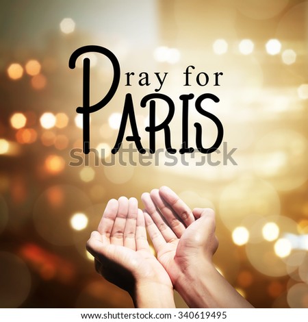 Human hand pray for paris incident, with blur city background
