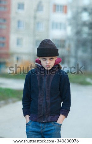dramatic portrait of a little homeless boy, poverty, city, street