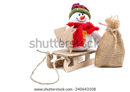 Snowman with sledge, bag and Christmas tree isolated on a white background.