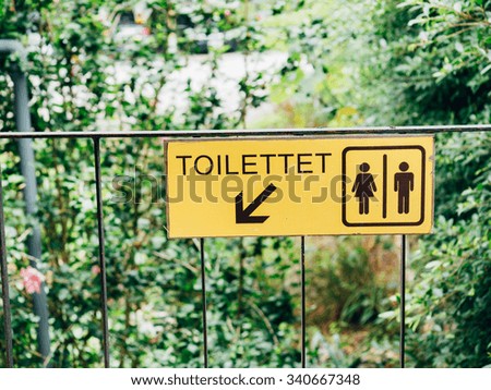 Toilet sign and direction on garden background