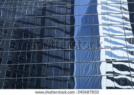 abstract  image of modern office building facade with reflections of sky and buildings