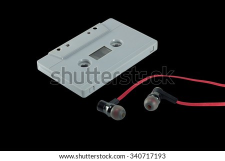 vintage cassette tape and red earphone isolated on black background