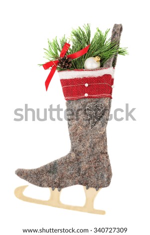 Christmas woolen stocking with decor and skate isolated on white background close up