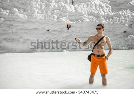 male tourist  taking picture of himself, selfie.  Natural travertine pools and terraces, Pamukkale, Turkey
