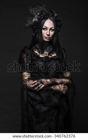 Portrait of beautiful Gothic woman in dark dress in studio