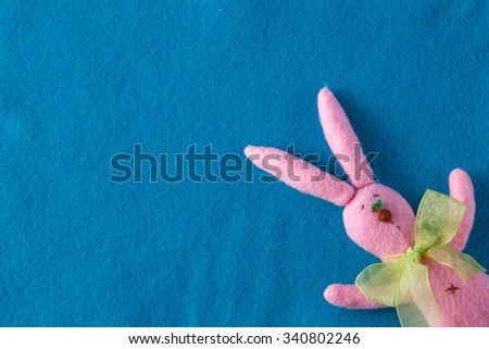 Kid toy play concept. Frame with soft felt and handmade funny pink rabbit
