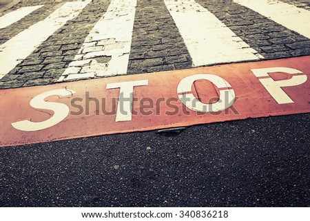 Pedestrian crossing road marking zebra and red stop line on urban road pavement