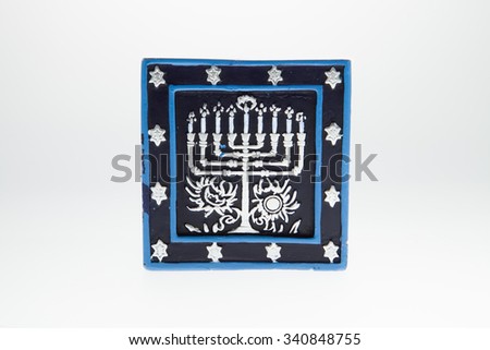 A candle with a menorah picture against a white background