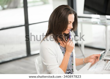Young attractive brunette working with tablet pc