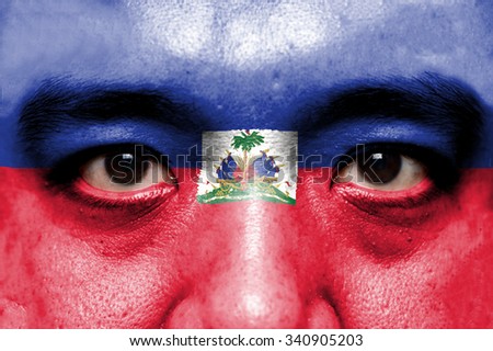 Human face painted with flag of Haiti.