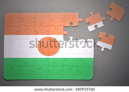 broken puzzle with the national flag of niger on a gray background