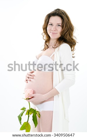 pregnant woman with a rose and her hands on her belly, isolated against white background
