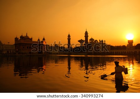 Cleaning the pool of the Golden Temple during sunset, Amritsar, India.