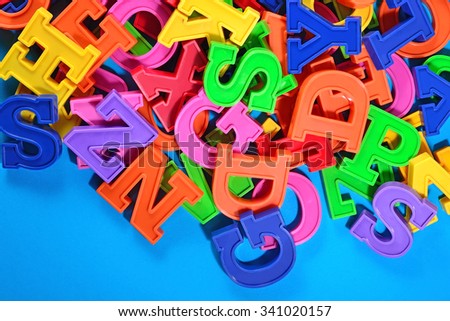 Colorful plastic alphabet letters on a blue background