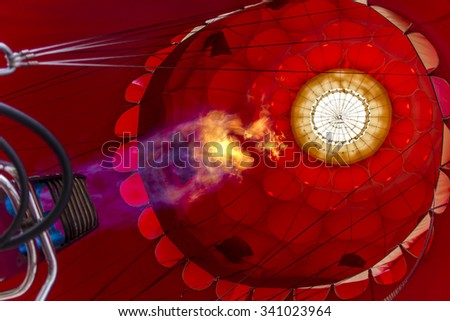 Red envelope of the hot air balloon with a fire from a burner