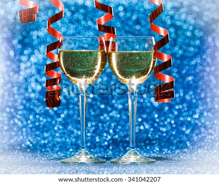 Two champagne glasses, decoration on glitter background