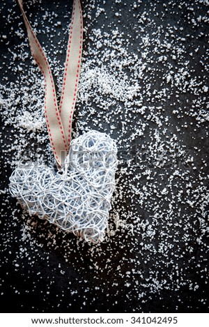 Handmade wire heart ornament on a slate and snow background