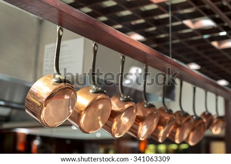 saucepans hanging from a rack in the  kitchen Royalty-Free Stock Photo #341063309
