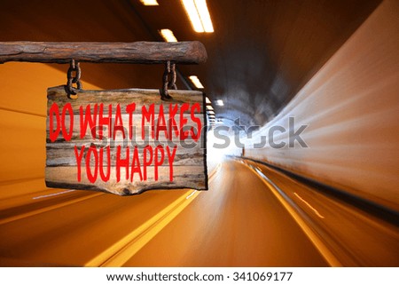 Do what makes you happy motivational phrase sign on old wood with blurred background